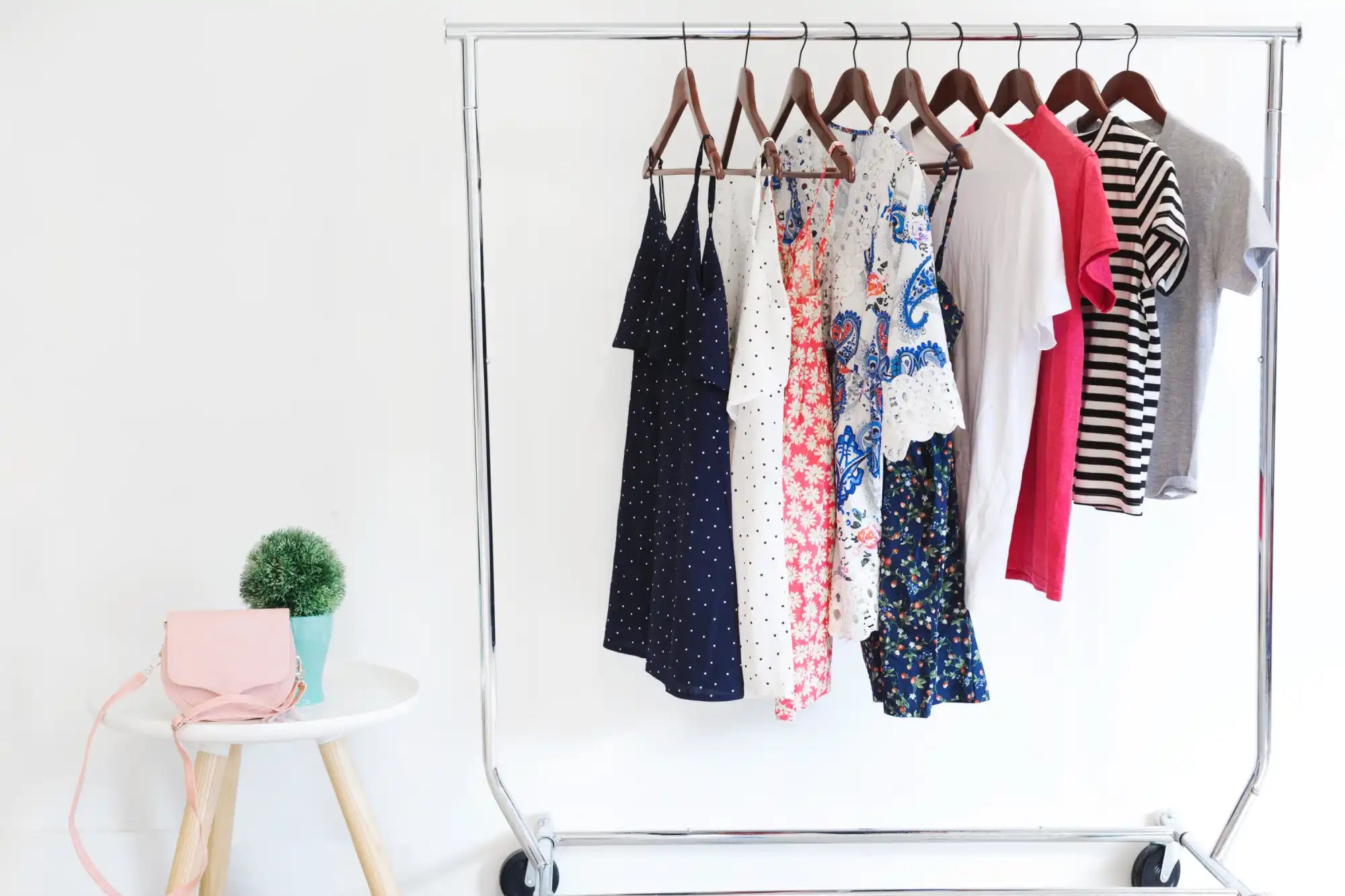 Clothes rack with dresses and shirts.